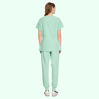 the BACK of a light green medical uniform for women, pants with ribbed ankle cuffs and top with v-neck